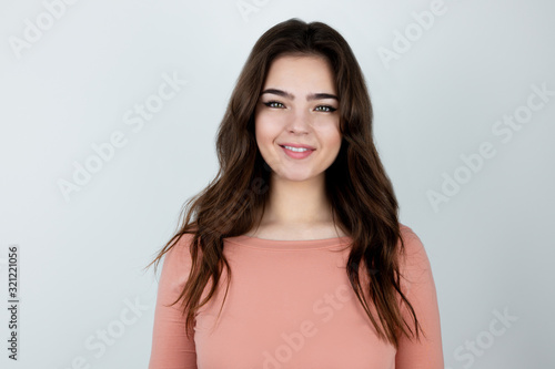 young beautiful brunette woman standing on isolated white background looking happy , pure beauty