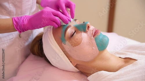 Spa Woman applying Facial cleansing Mask.