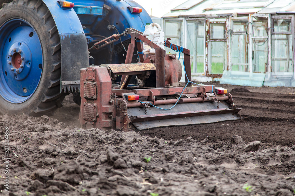A tractor plows the land on nature A tractor plows the land on nature
