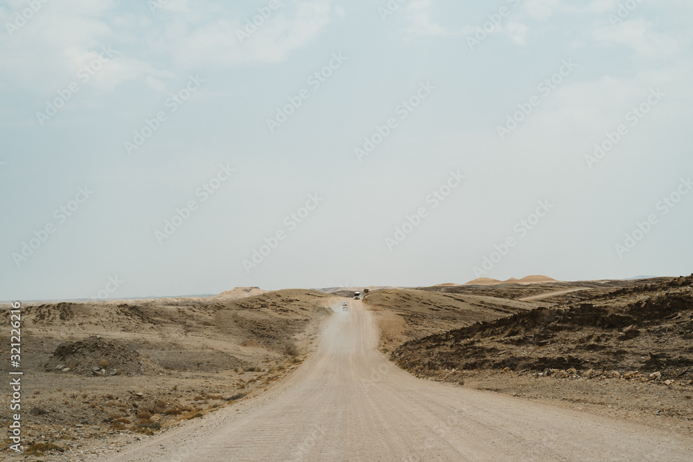 road through dead Moon Landscape with rocks, stones and mountains road through dead Moon Landscape with rocks, stones and mountains