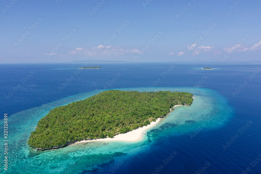 Atoll with a beautiful island, aerial view. White sand beach and blue sea. Mahaba Island, Philippines.