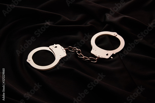 Photos metal handcuffs on black textile background
