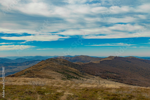 Carpathian Mountains top view landscape ridge autumn season dramatic weather time with cloudy blue sky background