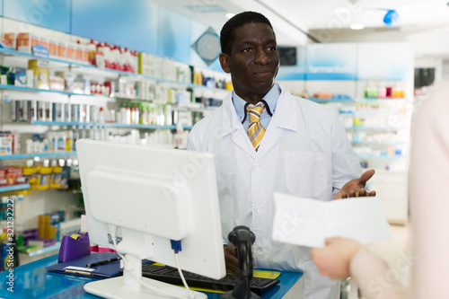 pharmacist taking prescriptions from customer