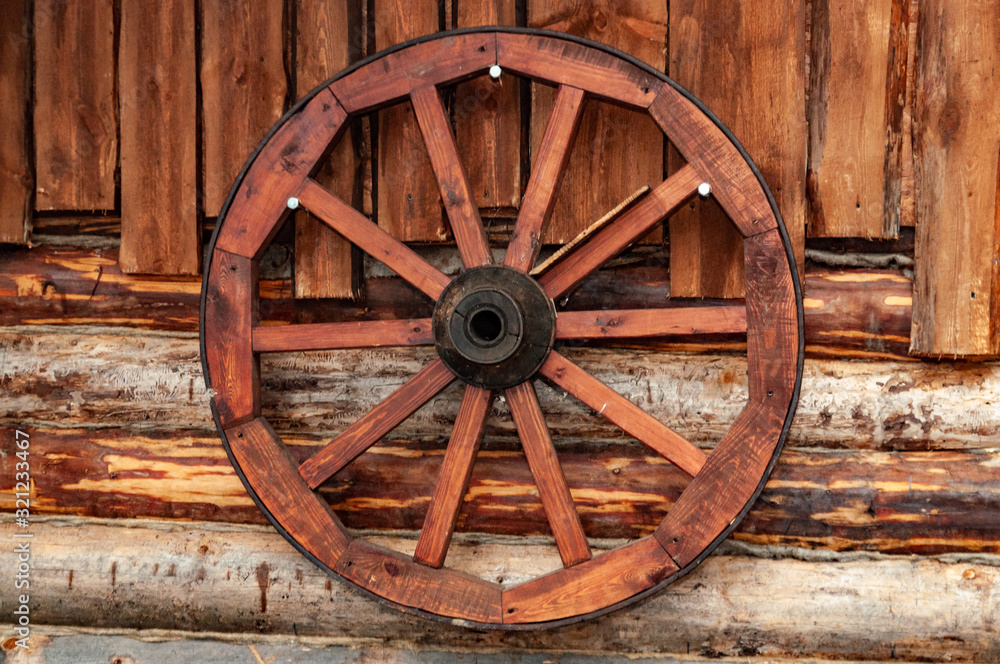 cart wheel on the wall of a wooden house