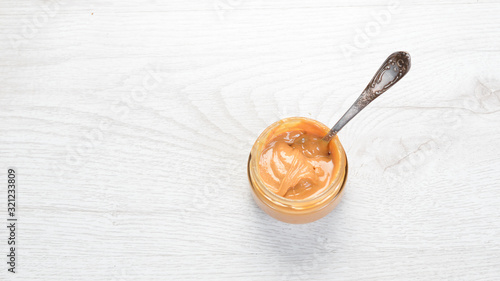 Peanut butter and nuts on a white wooden background. Free space for your text.