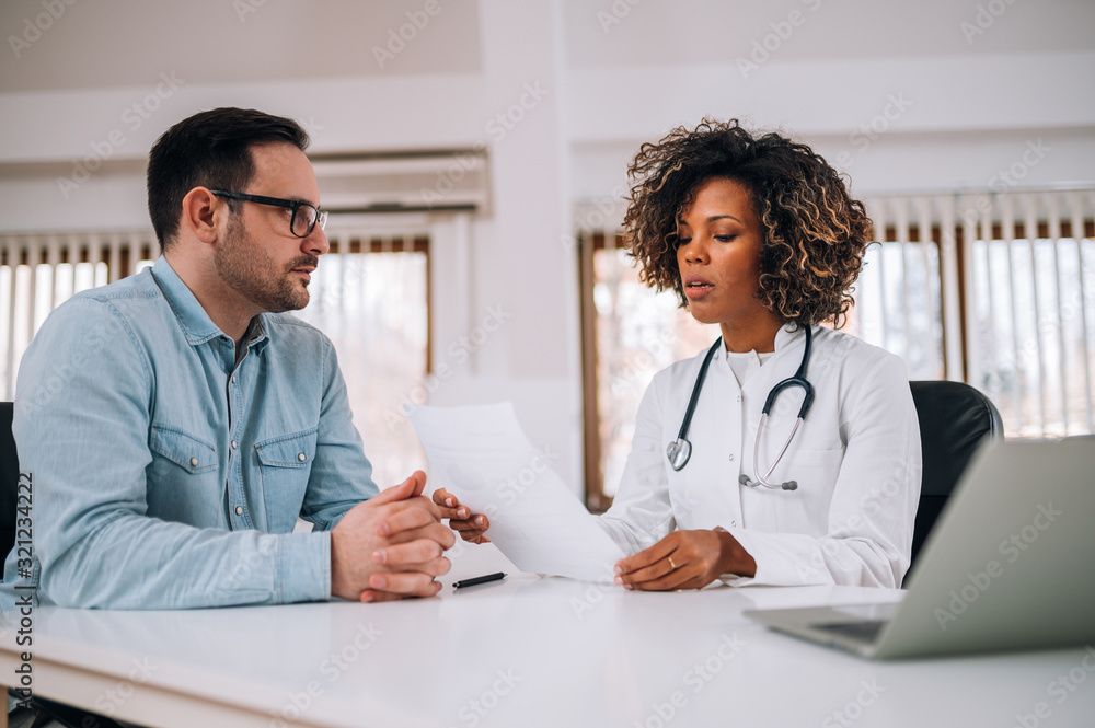 Portrait of a young doctor discussing with a patient. Portrait of a young doctor discussing with a patient.