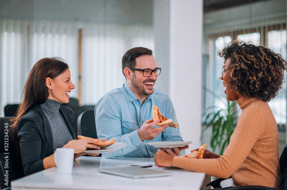 Obraz premium Friends laughing and eating pizza.
