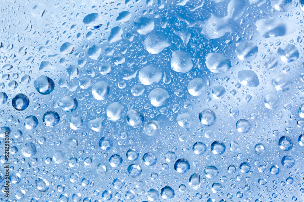 Backdrop glass covered with drops of water. Photo closeup with white and light blue background Backdrop glass covered with drops of water. Photo closeup with white and light blue background