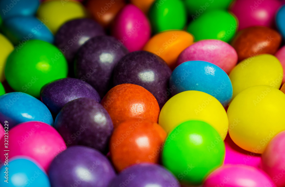 colorful round candies on a pink background. Mix of flavors and colors colorful round candies on a pink background. Mix of flavors and colors