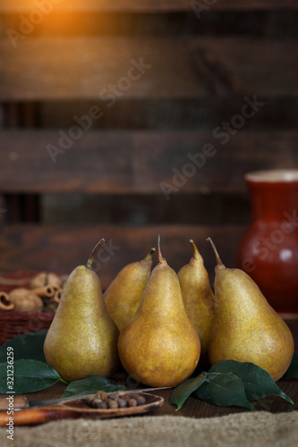 A group of ripe pears lie on old wooden boards.