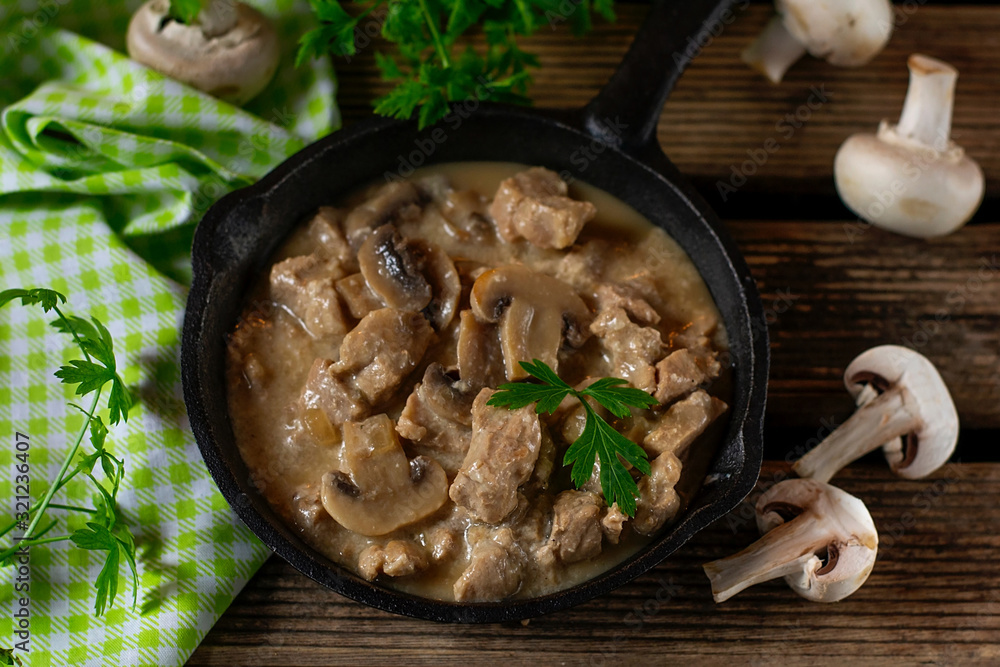 Slow cooked pork stew with mushrooms in creamy sauce Slow cooked pork stew with mushrooms in creamy sauce