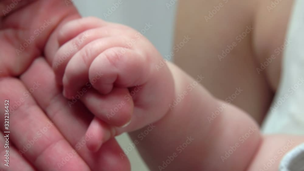 Sweet Little fingers of a baby hold adult hand of an adult parent Sweet Little fingers of a baby hold adult hand of an adult parent