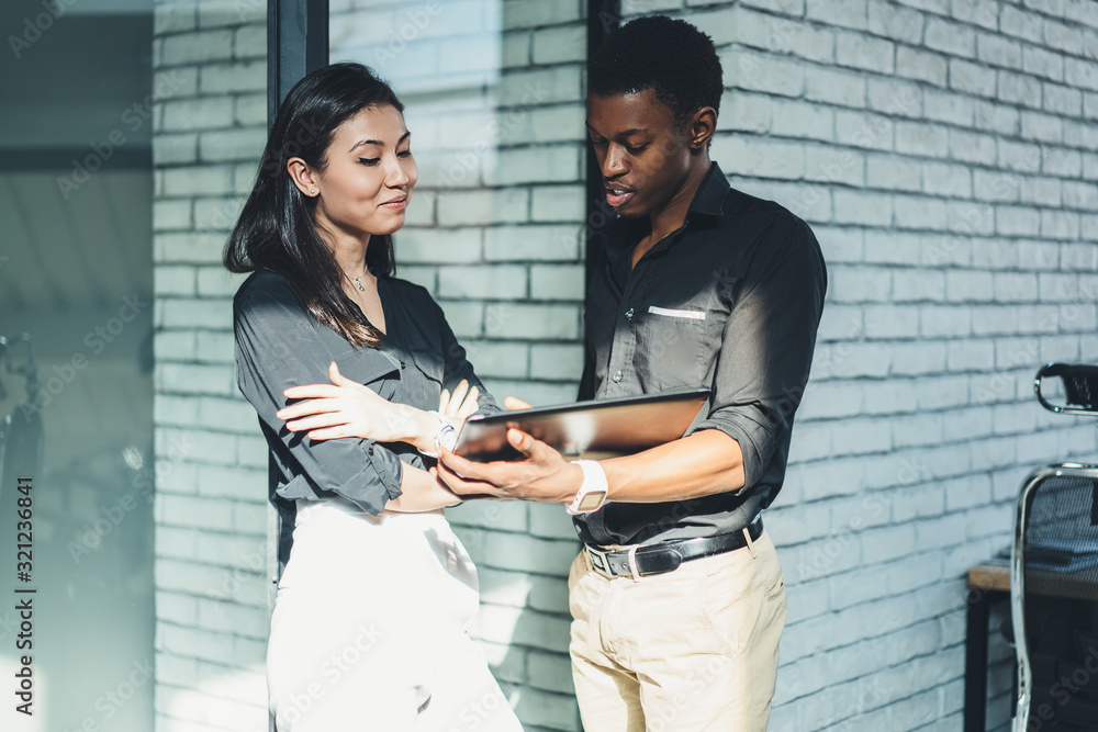 Black employee showing tablet to colleague Black employee showing tablet to colleague