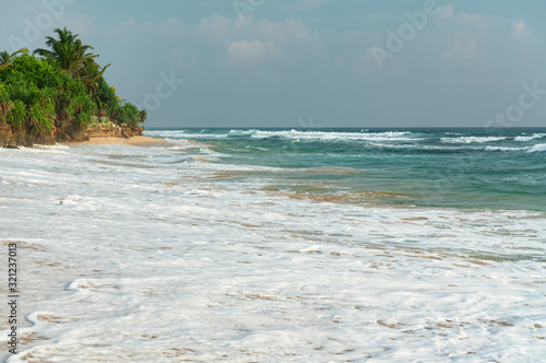 Ocean island beach landscape with blue water foam waves, Sri Lanka