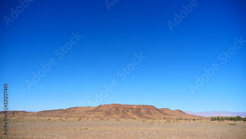 Bright landscape of Morocco, breathtaking curves of mountains, stunning combination of hills & farm land,inadvertent distribution of houses & huts, raw impression of pure nature.