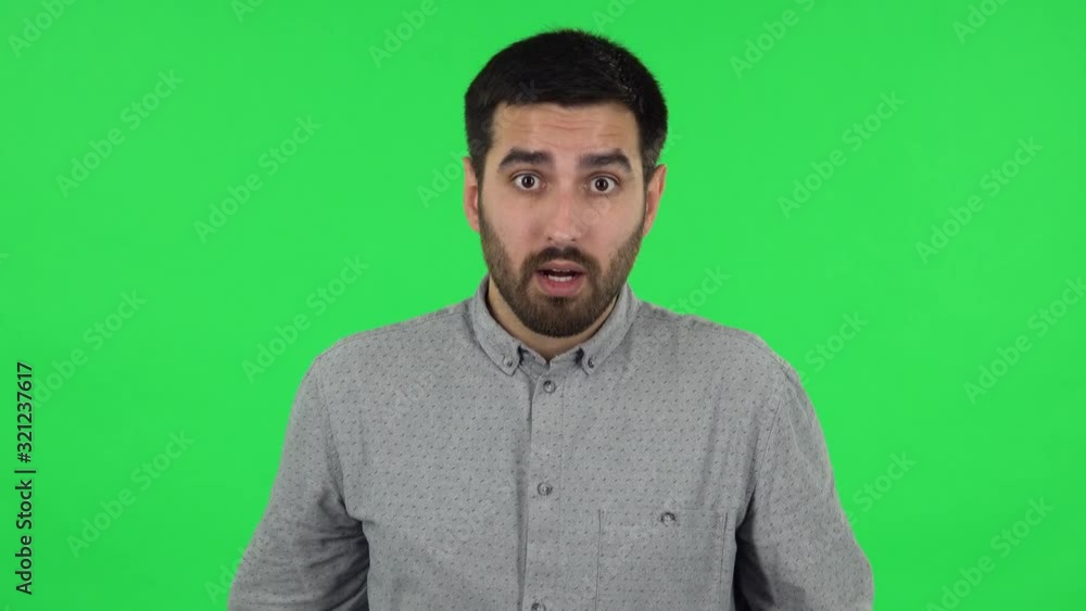 Portrait of brunette guy is waving his hands in indignation, shrugs. Green screen Portrait of brunette guy is waving his hands in indignation, shrugs. Green screen