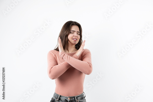 young beautiful brunette woman standing on isolated white background with her arms crossed, body language concept © studioprodakshn