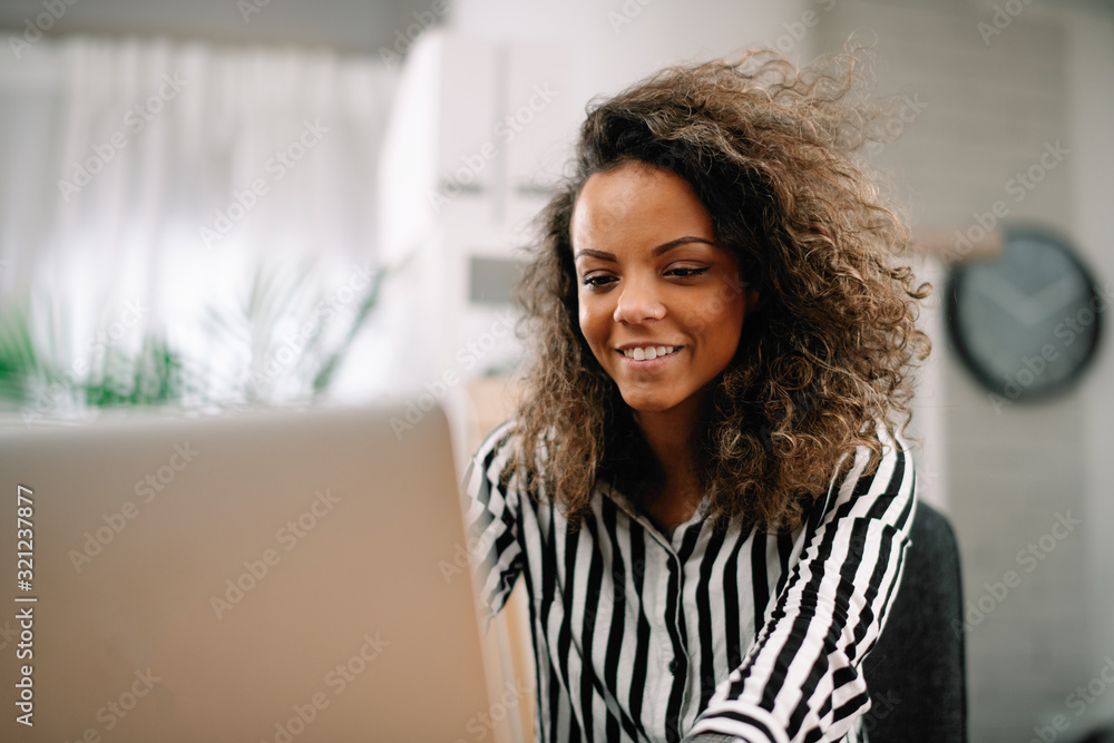 Young businesswoman in office. African beautiful woman using lap top. Young businesswoman in office. African beautiful woman using lap top.