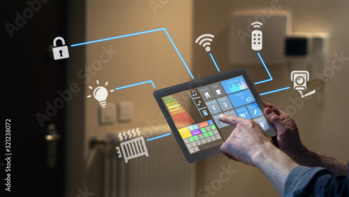 Close up of a man hand is using a futuristic latest innovative technology glass tablet with augmented reality holograms as a remote control of smart home appliances at home or office. photo