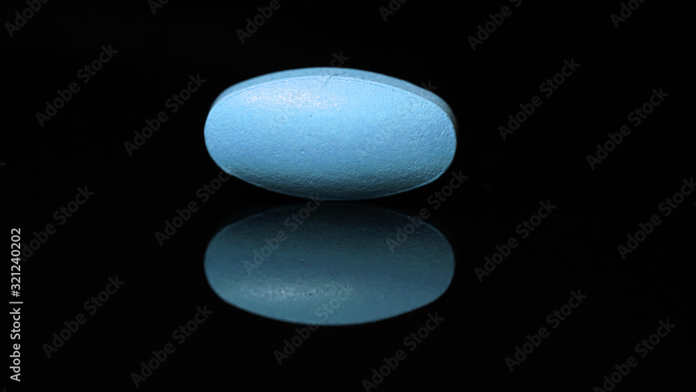 oval tablet isolated on a black background with reflections. Close-up Photo. oval tablet isolated on a black background with reflections. Close-up Photo.