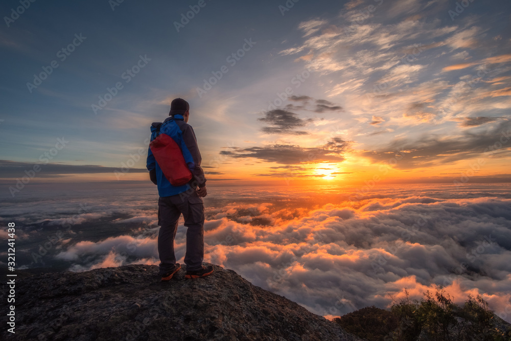 silhouette of man on top of mountain at sunset