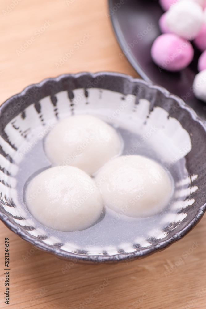 Tang yuan, tangyuan, yuanxiao in a small bowl. Delicious asian traditional festive food rice dumpling balls with stuffed fillings for Chinese Lantern Festival, close up. Tang yuan, tangyuan, yuanxiao in a small bowl. Delicious asian traditional festive food rice dumpling balls with stuffed fillings for Chinese Lantern Festival, close up.