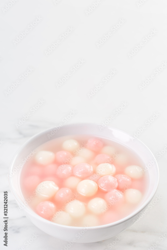 Tang yuan, tangyuan, delicious red and white rice dumpling balls in a small bowl. Asian traditional festive food for Chinese Winter Solstice Festival, close up. Tang yuan, tangyuan, delicious red and white rice dumpling balls in a small bowl. Asian traditional festive food for Chinese Winter Solstice Festival, close up.