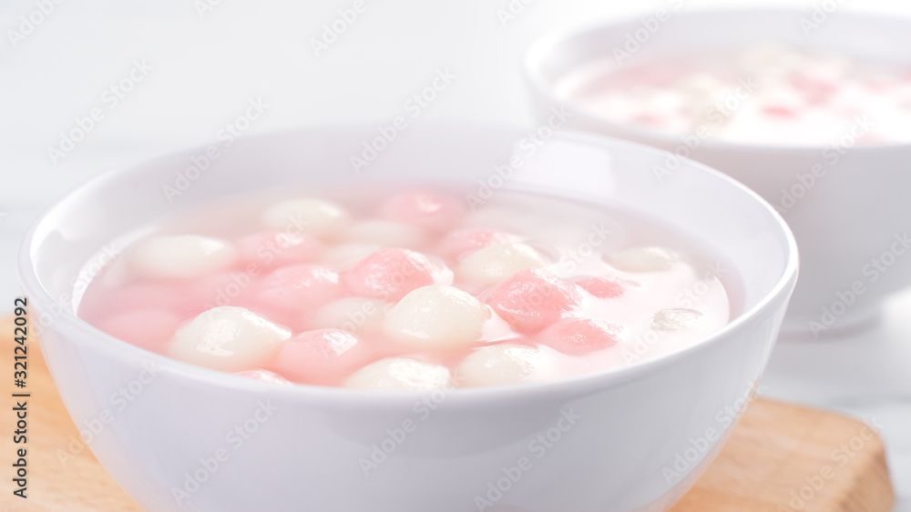 Tang yuan, tangyuan, delicious red and white rice dumpling balls in a small bowl. Asian traditional festive food for Chinese Winter Solstice Festival, close up. Tang yuan, tangyuan, delicious red and white rice dumpling balls in a small bowl. Asian traditional festive food for Chinese Winter Solstice Festival, close up.