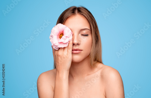 Beautiful female model with flower near eye