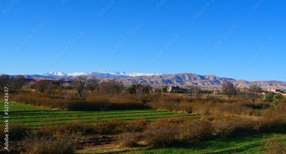 Bright landscape of Morocco, breathtaking curves of mountains, stunning combination of hills & farm land,inadvertent distribution of houses & huts, raw impression of pure nature.