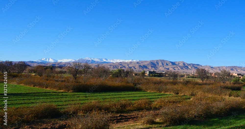 Naklejka premium Bright landscape of Morocco, breathtaking curves of mountains, stunning combination of hills & farm land,inadvertent distribution of houses & huts, raw impression of pure nature.