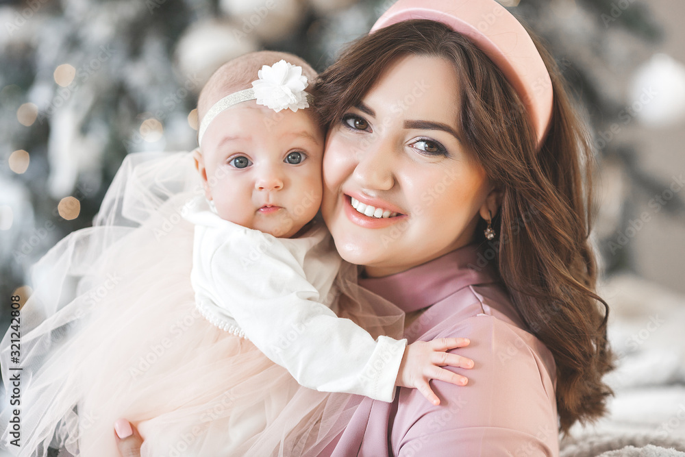 Obraz premium Young attractive mother carrying her little baby. Mom holding her cute child. Happy young family indoors.