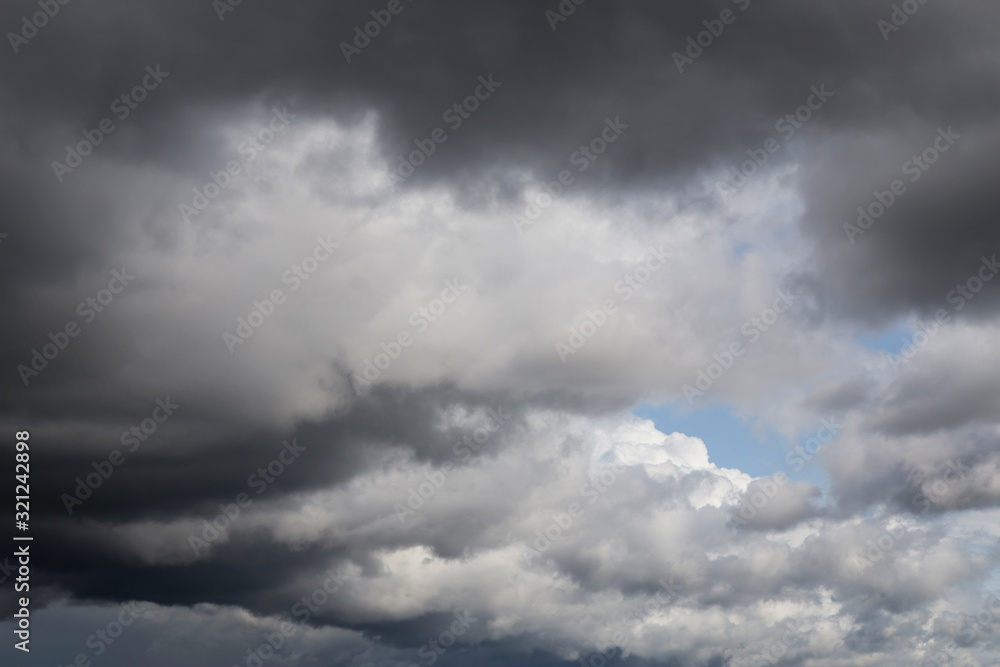Obraz premium Dramatic storm grey cumulus clouds against blue sky background texture