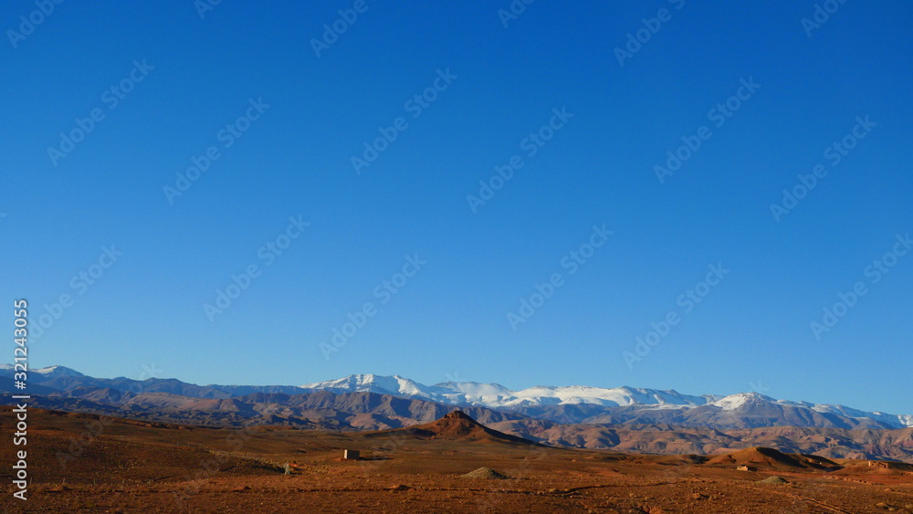 Naklejka premium Bright landscape of Morocco, breathtaking curves of mountains, stunning combination of hills & farm land,inadvertent distribution of houses & huts, raw impression of pure nature.