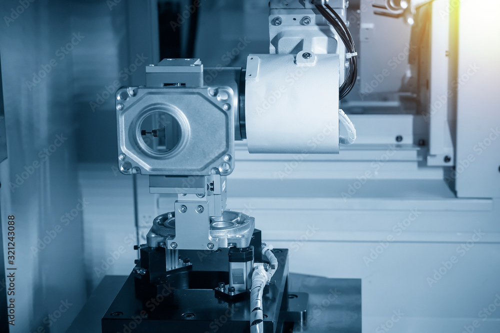 The robotic arm system working with the CNC milling machine for parts setup process .The hi-technology automotive part manufacturing process by robotic system. The robotic arm system working with the CNC milling machine for parts setup process .The hi-technology automotive part manufacturing process by robotic system.