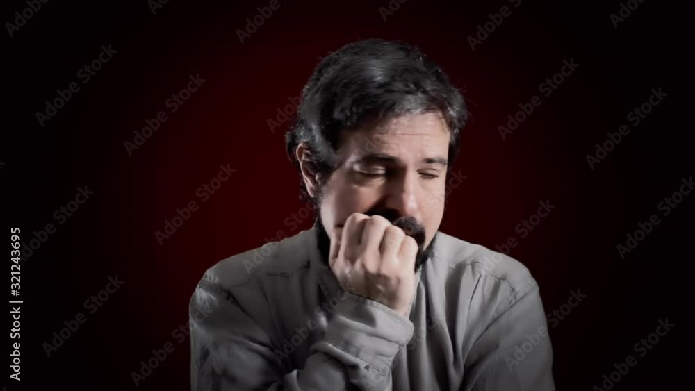 An awkward man's expression. Medium close-up shot of the face over a red background. Part of a series of depictions of feelings and emotions with professional actors. An awkward man's expression. Medium close-up shot of the face over a red background. Part of a series of depictions of feelings and emotions with professional actors.