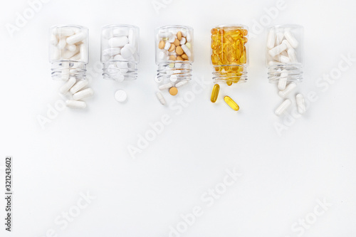 Five packs with various white and golden pills on a white background. Health concept. Top view with copy space.