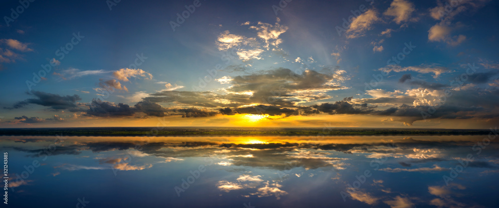 Panorama aerial view photo Reflection of vivid sunset sky over sea.Colorful sunrise with Clouds over ocean.Sky reflection on water