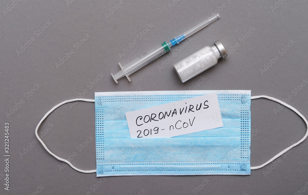 Protective mask and papers with an inscription of Coronavirus` symptoms. Medicine concept. Protective mask and papers with an inscription of Coronavirus` symptoms. Medicine concept.