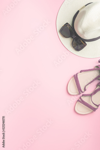 Straw hat, sunglasses and dar red shoes on pink background, beach holiday concept. Top view, toned, selective focus