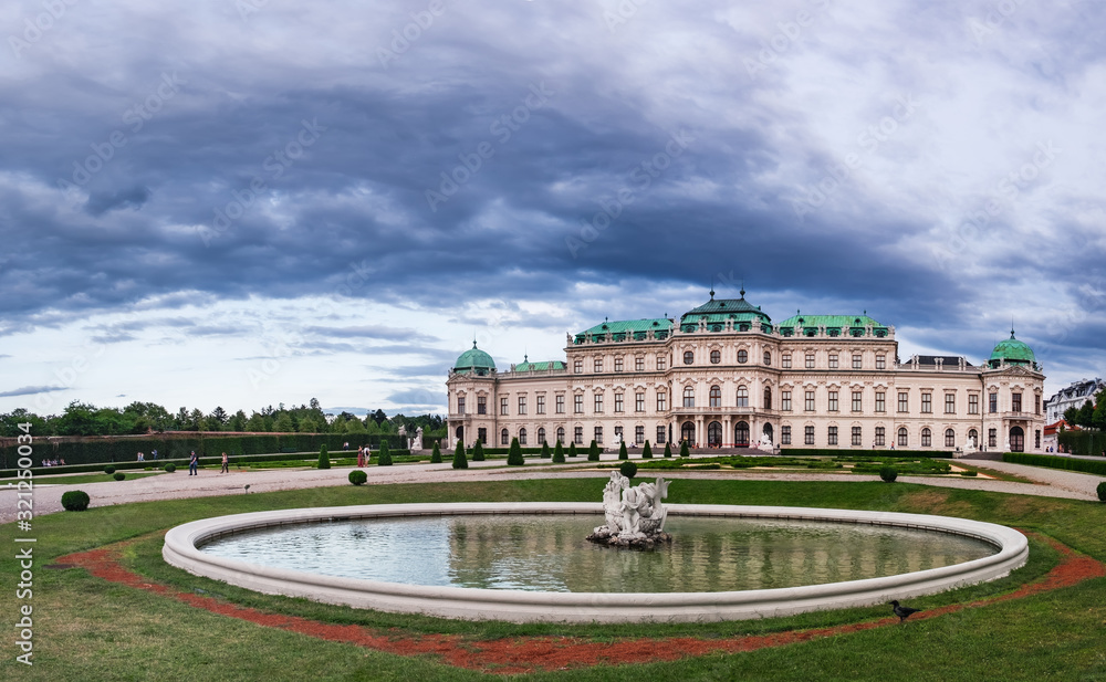 Facade of Belvedere Palace, located in the center of Vienna, Austria. Royal palace and fountain under blue cloudy sky