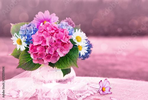 Foto Colorful flowers bouquet in glass vase isolated on pink.