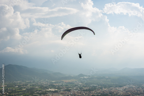 colorful paragliding over blue sky at town