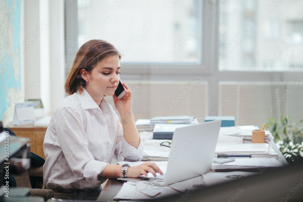 Woman in office working, reading a document - obrazy, fototapety, plakaty 
