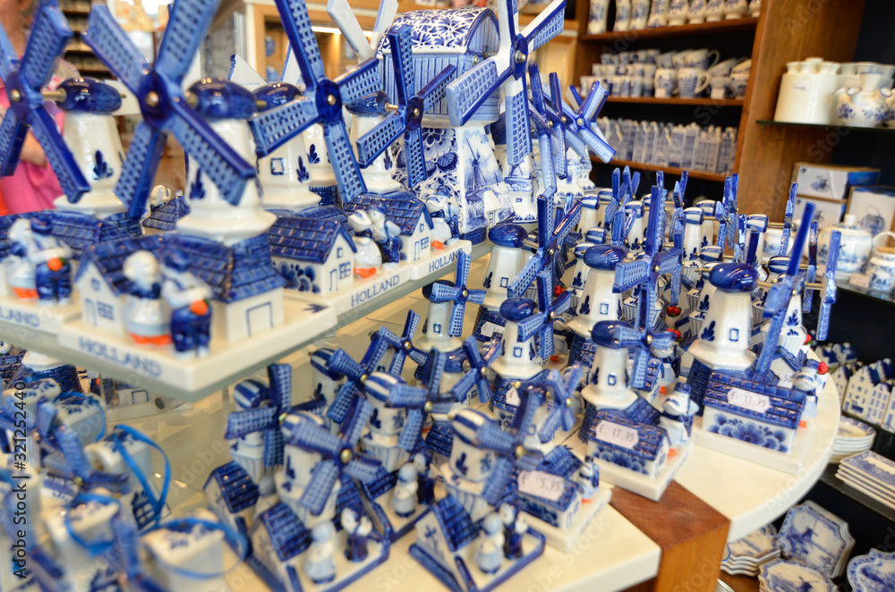 Delft, the netherlands, august 2019. At a shop of the famous white and blue ceramics of miniature windmills to buy as a souvenir. Delft, the netherlands, august 2019. At a shop of the famous white and blue ceramics of miniature windmills to buy as a souvenir.