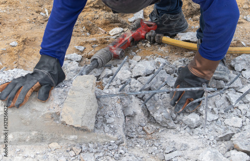 Steel bars and broken concrete are formed by the extraction of red wind machines placed on the floor of the workers and are removing the cement from the steel bars. Concrete extraction tools Road 