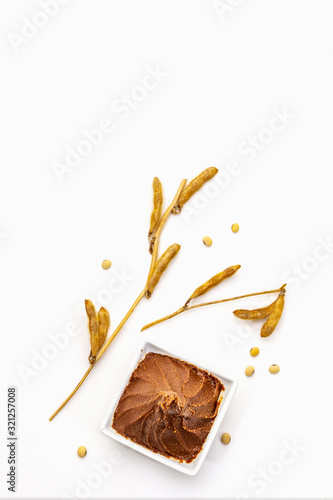 Light brown miso paste isolated on white background. Traditional Japanese seasoning, dry soya beans pods photo