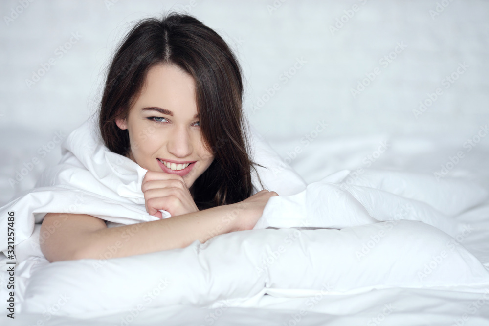 Playful young woman hiding face under blanket while lying in cozy bed on white pillow, pretty curious girl feeling shy peeking from duvet, covering with white sheet, head shot close up, top view Playful young woman hiding face under blanket while lying in cozy bed on white pillow, pretty curious girl feeling shy peeking from duvet, covering with white sheet, head shot close up, top view