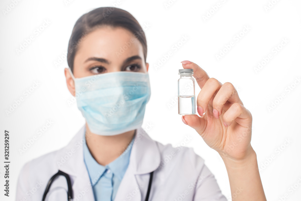 Selective focus of doctor in medical mask holding jar with vaccine isolated on white Selective focus of doctor in medical mask holding jar with vaccine isolated on white